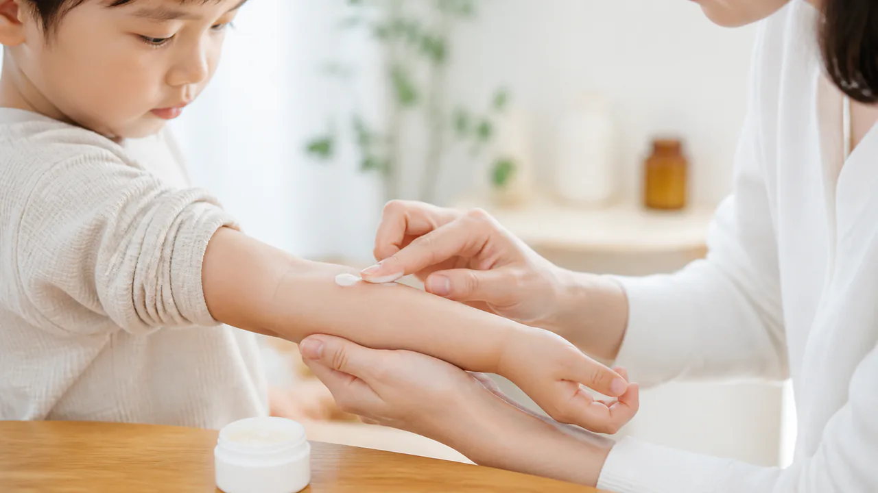 アトピー性皮膚炎治療で軟膏を塗布する親と子どもの手元