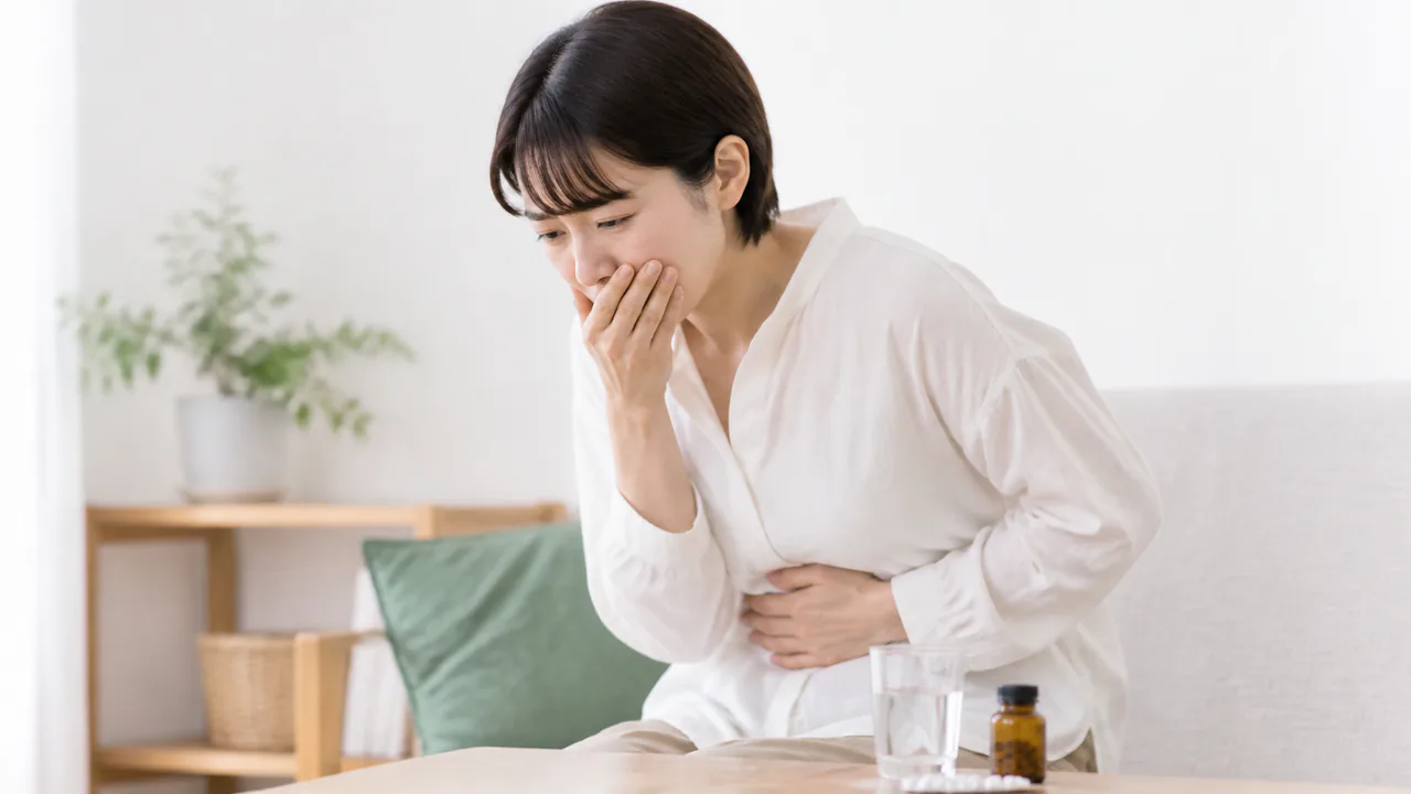 ロキソニン錠服用による胃痛や吐き気などの副作用を表現する人物の様子